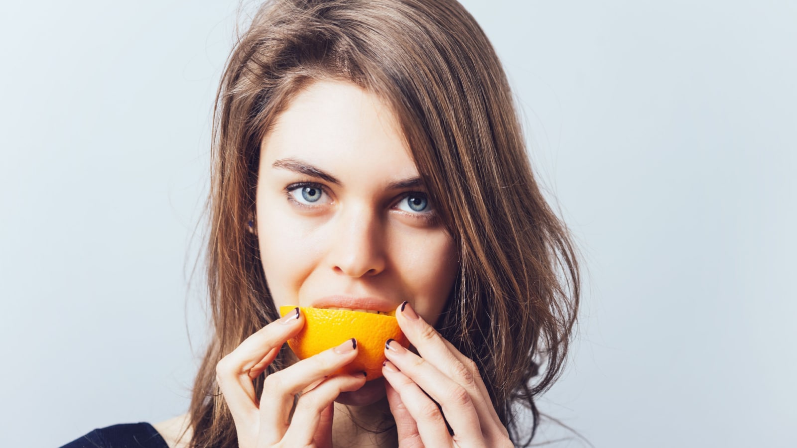 woman eating orange