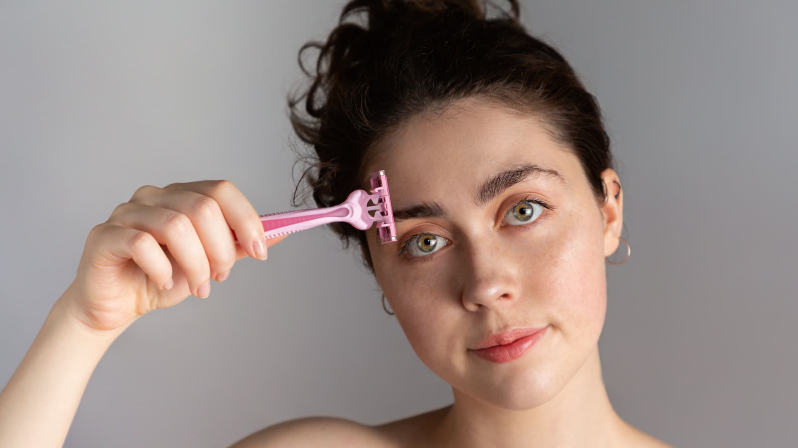 woman shaving eyebrow