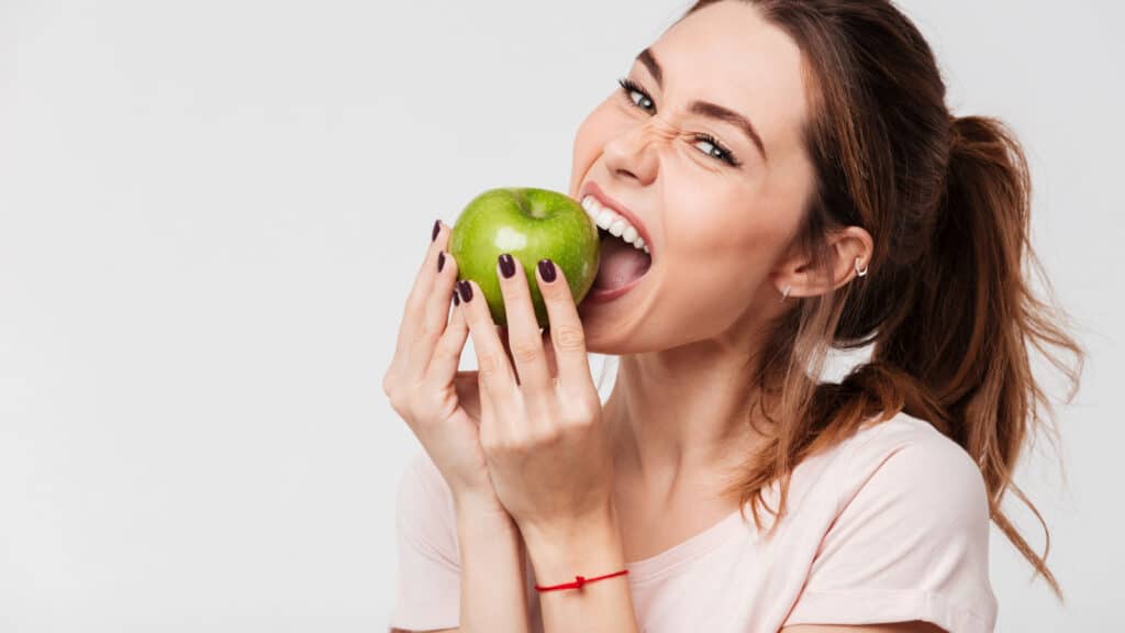 woman biting apple funny