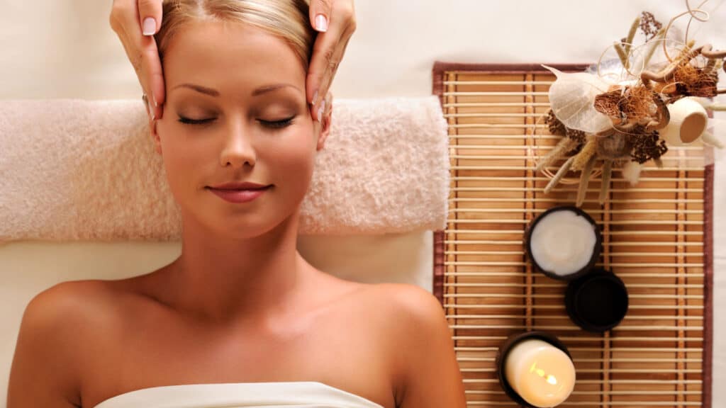 woman getting head massage candles