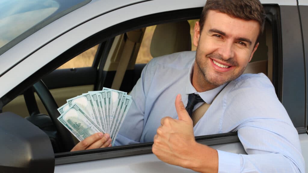 man in car with money