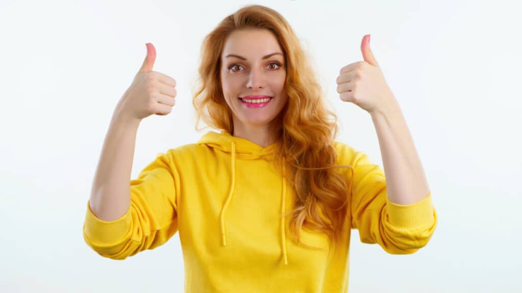 happy smiling woman giving double thumbs up reaction
