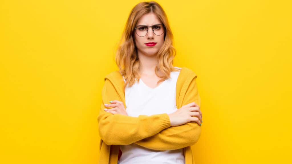 judging woman in glasses yellow crossing arms
