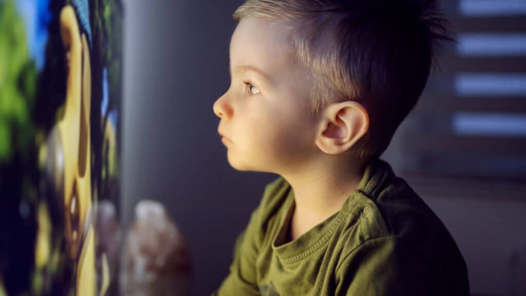 kid sitting close to TV screen