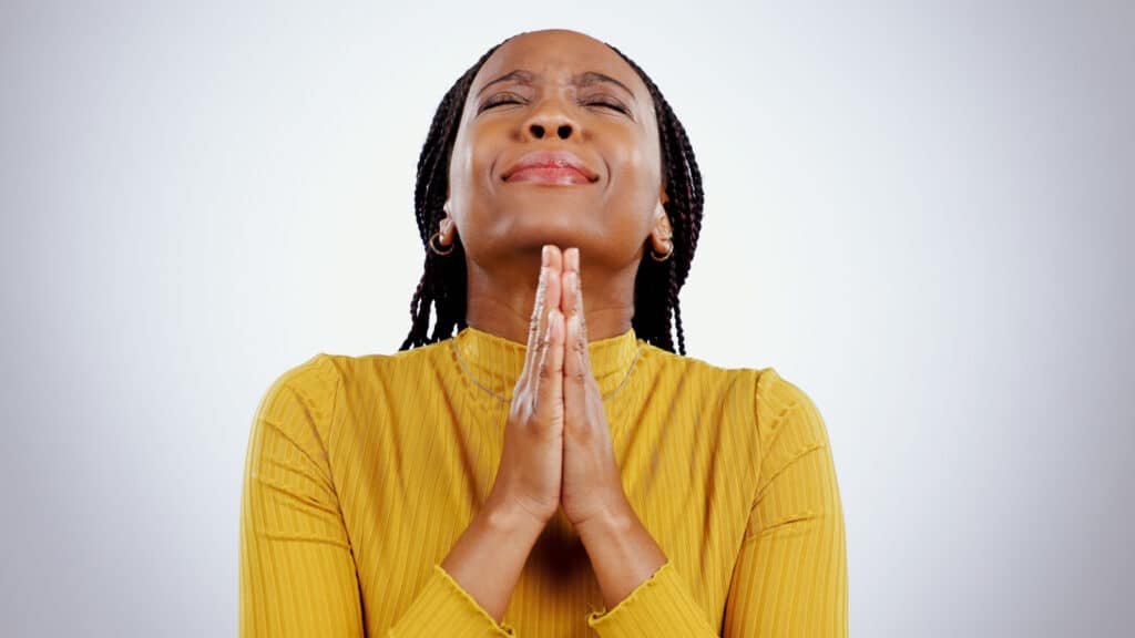 Black woman praying faithfully to God